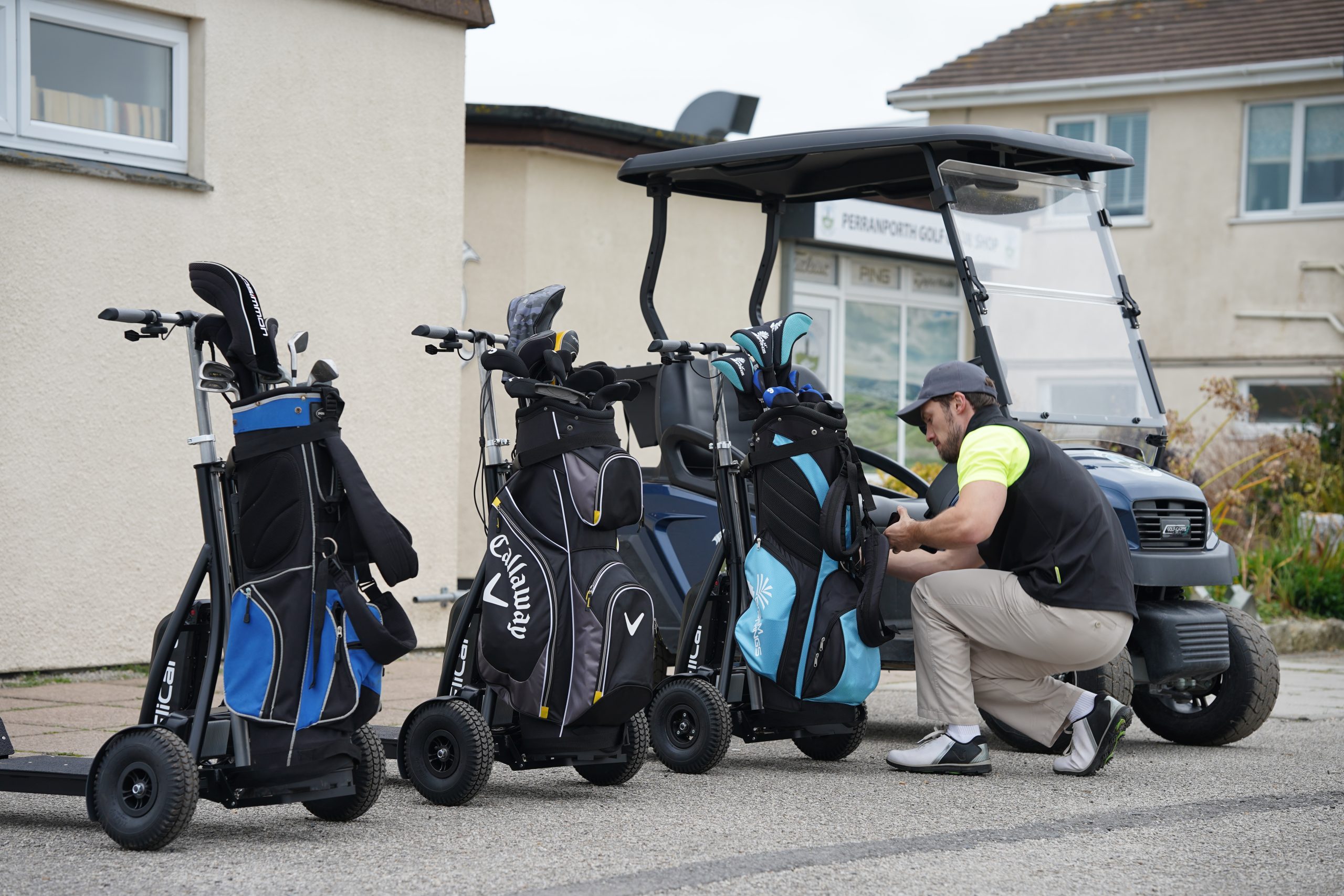 FliCart golf caddies lined up next to a golf cart